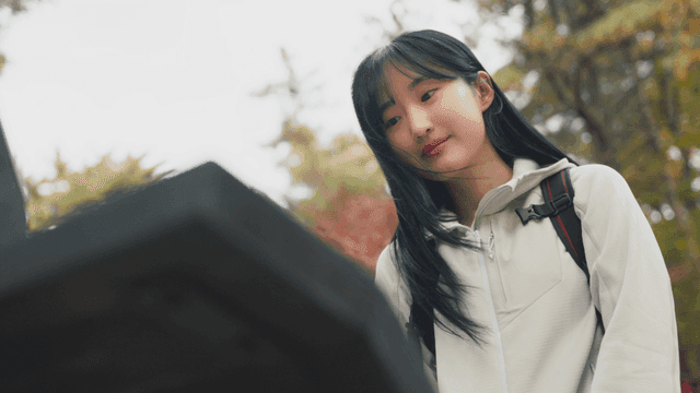 Young woman checking trail sign on autumn foliage path