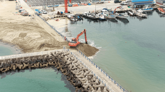 해안 부두에서 작업 중인 굴착기