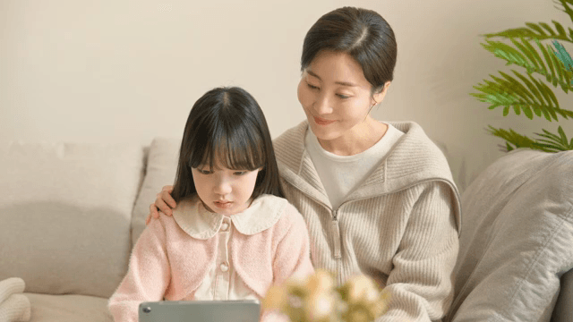 엄마와 딸이 함께 태블릿을 사용하는 모습