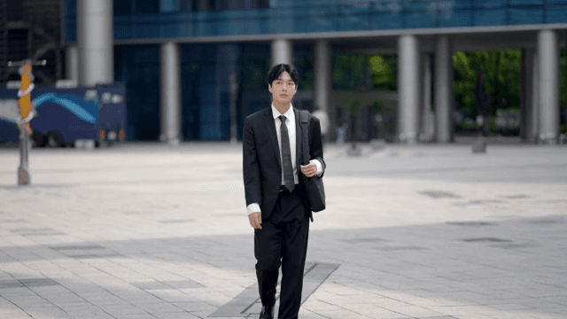 Male office worker walking in front of a company building