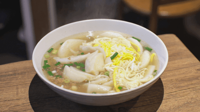 Steaming bowl of rice cake and dumpling soup