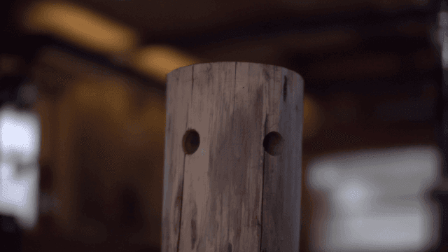 Wooden log with drilled holes in a workshop