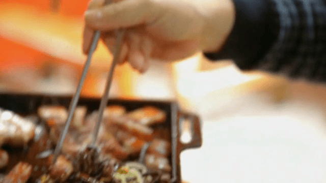 불판 위 채소와 함께 집어 든 삼겹살