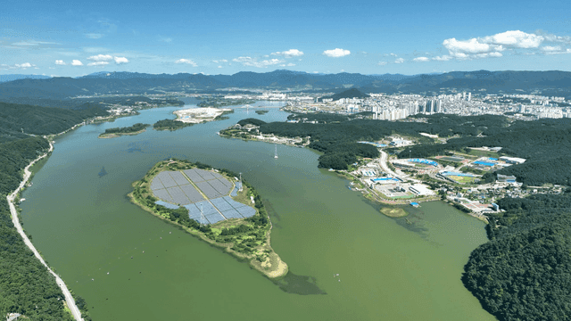 Aerial view of a city with a river and greenery