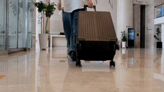 호텔 로비에서 캐리어를 끌고 걷는 사람
