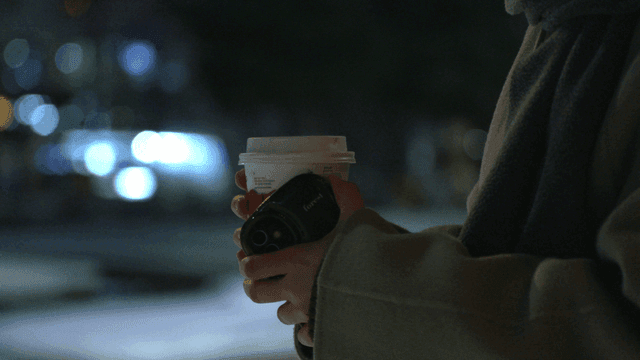 Person holding warm cup of coffee on cold night