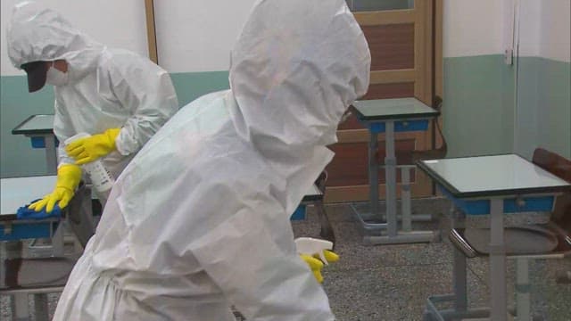 Person Sanitizing Classrooms in Protective Suit