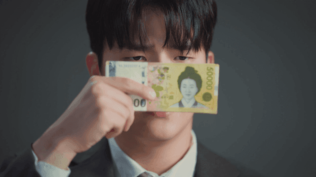 돈으로 얼굴을 가리며 상반된 표정을 보이는 남자