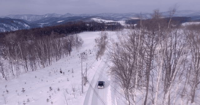 눈 덮인 숲을 달리는 자동차
