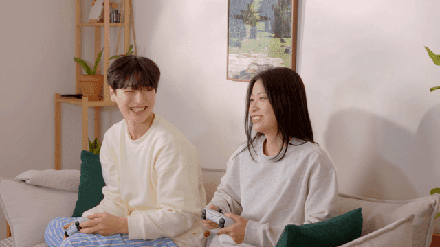 Couple playing console games on sofa