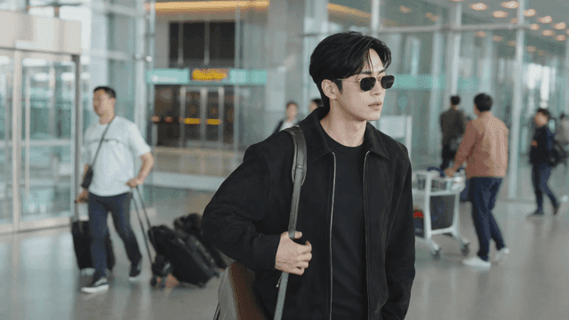 공항 터미널을 선글라스를 끼고 걷는 남성
