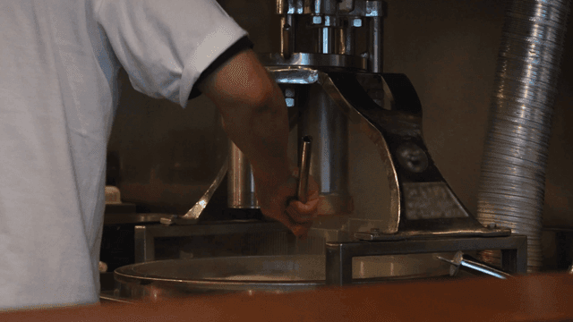 주방에서 업소용 제면기로 면을 뽑아내는 요리사