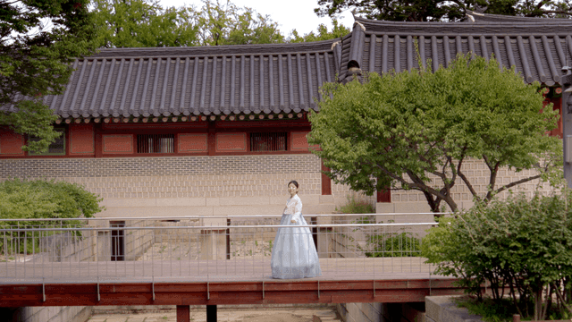Woman in hanbok walking in a traditional Korean house