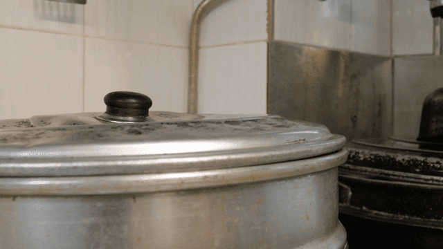 Steaming pot lid on kitchen stove