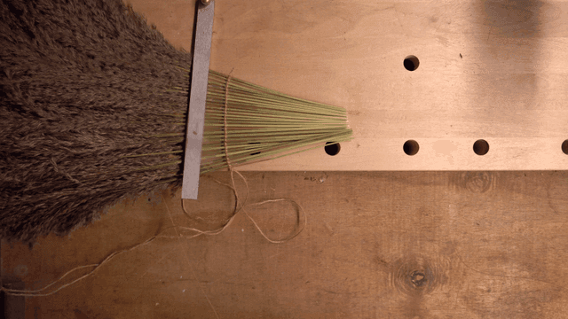 작업대에서 갈대를 다듬는 사람