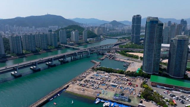 강 위에 교차하는 고속도로와 높은 건물들로 북적이는 도심 풍경