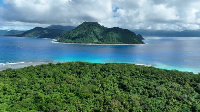 Aerial view of a lush green island surrounded by blue ocean