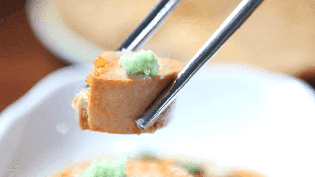 Chopsticks holding piece of monkfish liver
