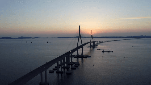 Bridge and ships at sunset over the sea