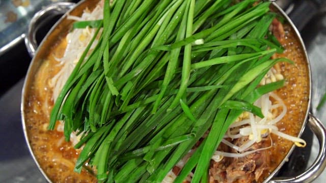 Pork backbone stew topped with chives and bean sprouts