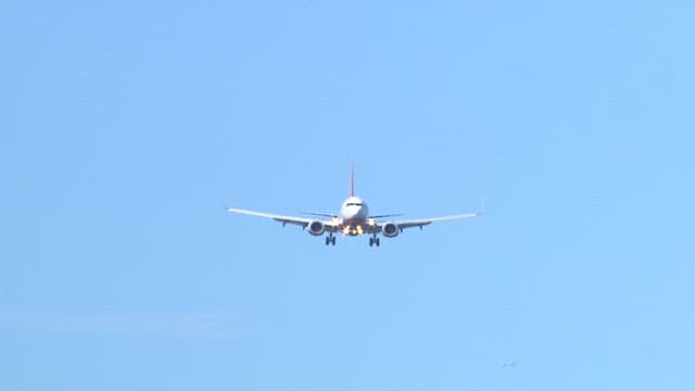 Airplane Descending Against Clear Blue Sky