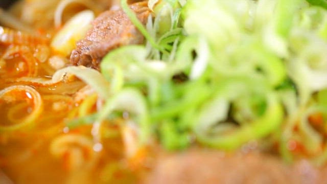 Beef and rice soup topped with green onions