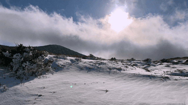 Snow-covered mountain under bright sun