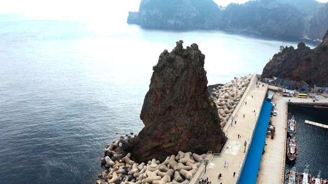 View of seaside town with rocky cliffs and pier