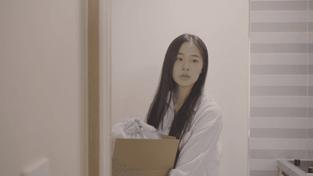 분리수거 상자를 들고 불을 끄고 나가는 여성