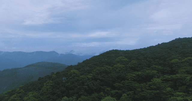 Lush green mountains under a cloudy sky