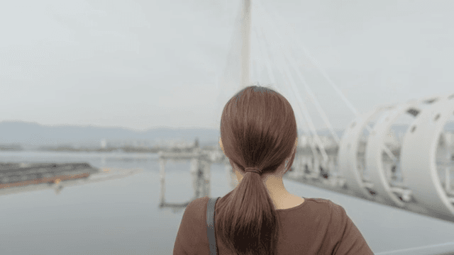 다리 위에서 풍경을 내려다보는 여성