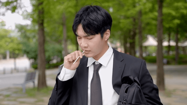 야외에서 음료를 마시며 목을 축이는 직장인 남성