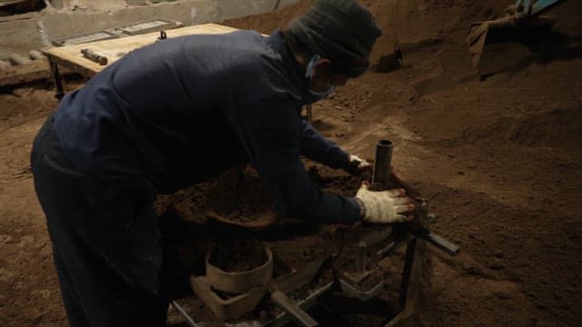 Worker shaping sand mold in a workshop