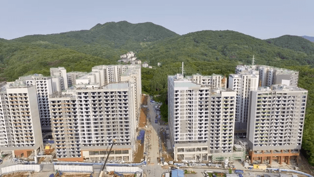 Modern apartment buildings with green hills