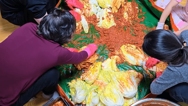 실내에서 함께 김치를 담그는 사람들