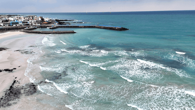Coastal village with beach where calm waves crash