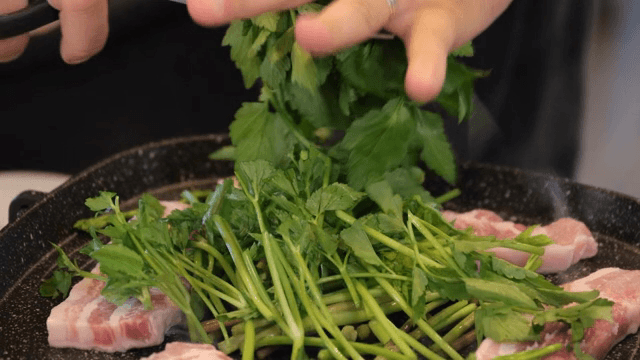 Fresh water parsley being cut over pork slices