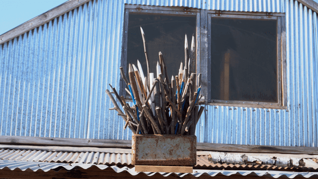 지붕 위에 놓인 나뭇가지 연필 조각품