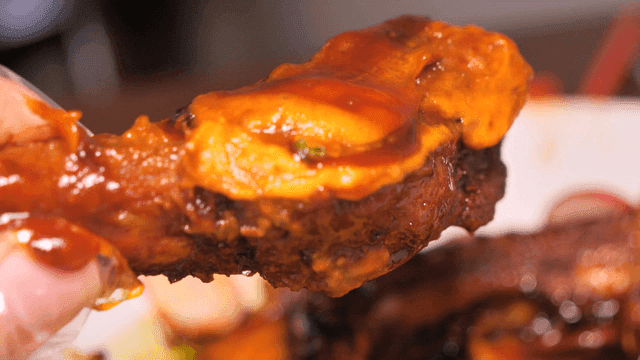 Spicy marinated short ribs served with spoonful of sauce