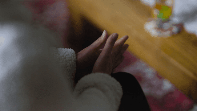 Hands clasped together in a cozy room