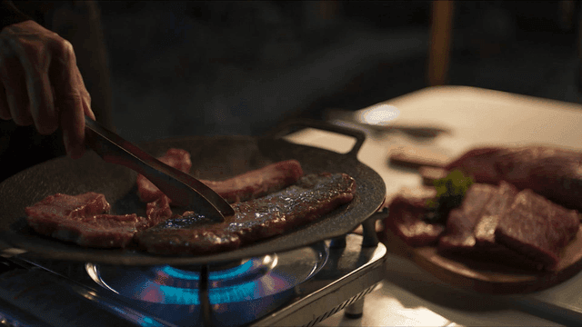 Beef sizzling on grill
