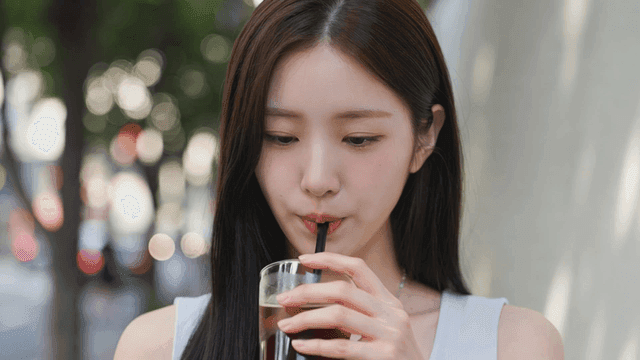 길거리에서 아이스 아메리카노를 마시는 여성