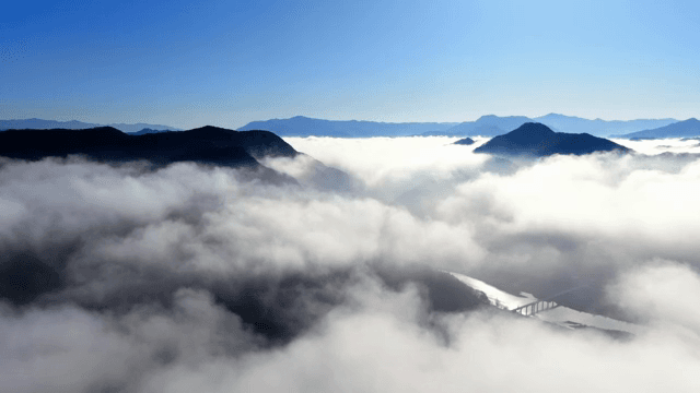 맑은 하늘 아래 구름에 덮인 산