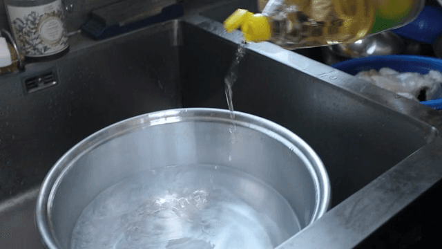 주방에서 냄비에 식초를 붓는 장면