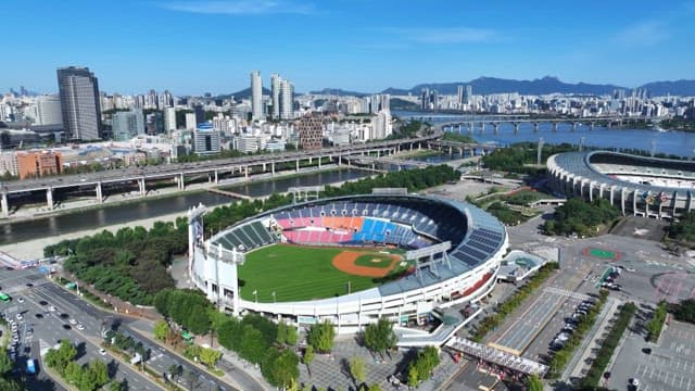 Overview of a city with a stadium and river on a sunny and clear day