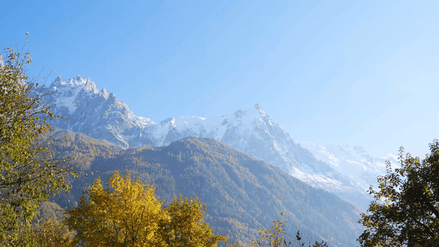 Snow-covered mountain landscape with autumn foliage