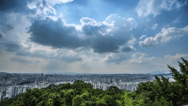 Cityscape with clouds and greenery