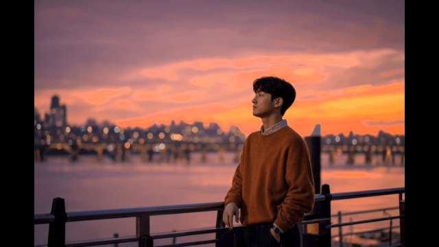 Man watching sunset by river