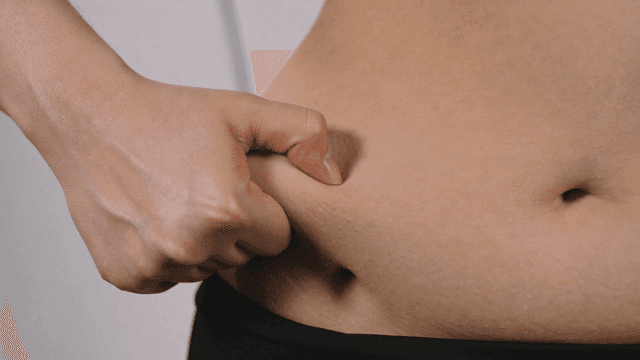 Hands that pick up abdominal fat skin