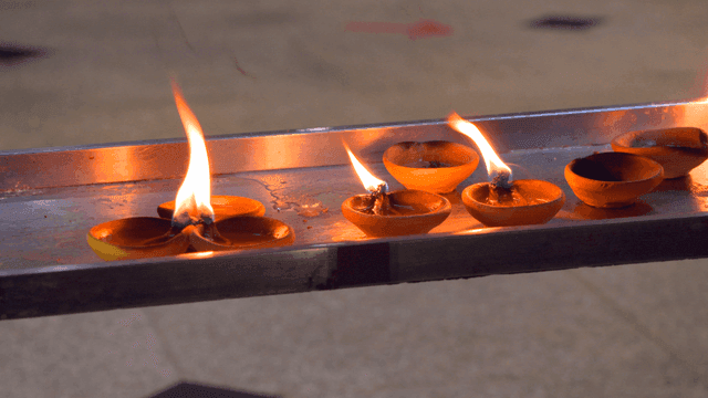 금속 트레이 위에서 타오르는 촛불